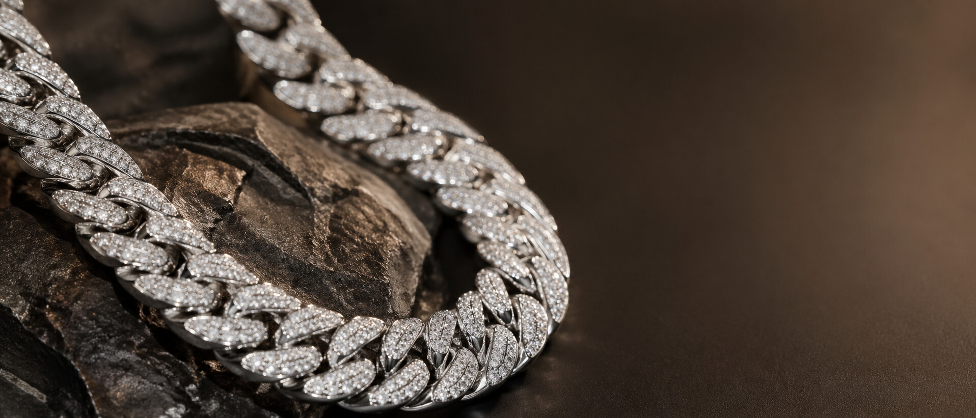 Pave diamond Cuban link chain resting on dark stone